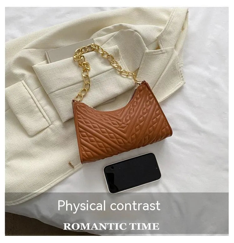 Brown pleated chain baguette women's shoulder bag with adjustable strap on a mannequin.