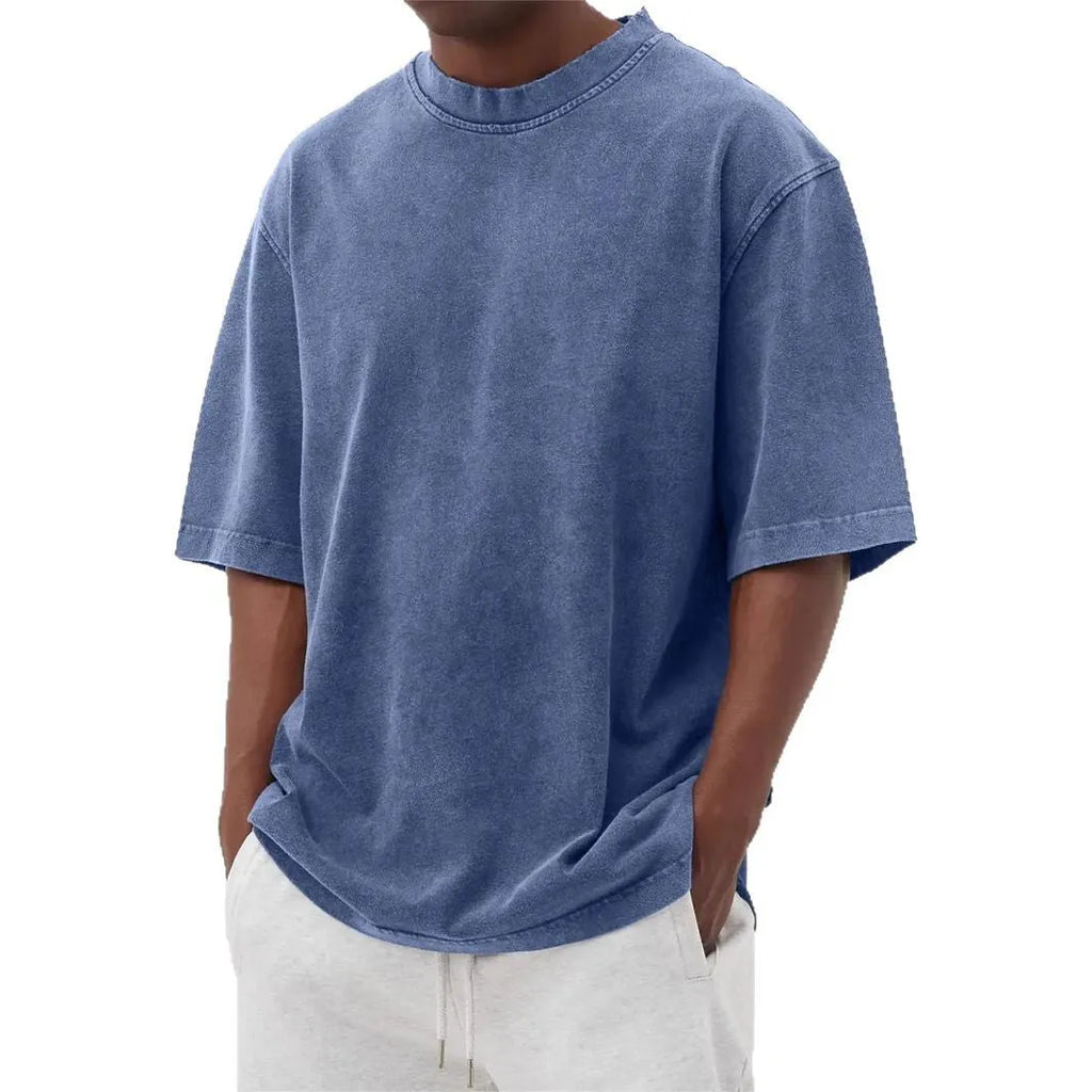 Man wearing a loose-fit distressed pullover T-shirt in a solid colour, showcasing the casual style and half-sleeve design.