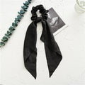 Long spring dark green cloth ribbon attached to a large intestine ring hair accessory for women.