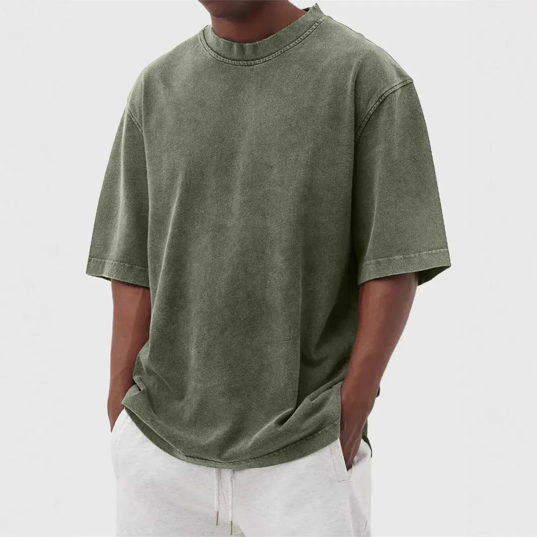 Man wearing a loose-fit distressed pullover T-shirt in a solid colour, showcasing the casual style and half-sleeve design.