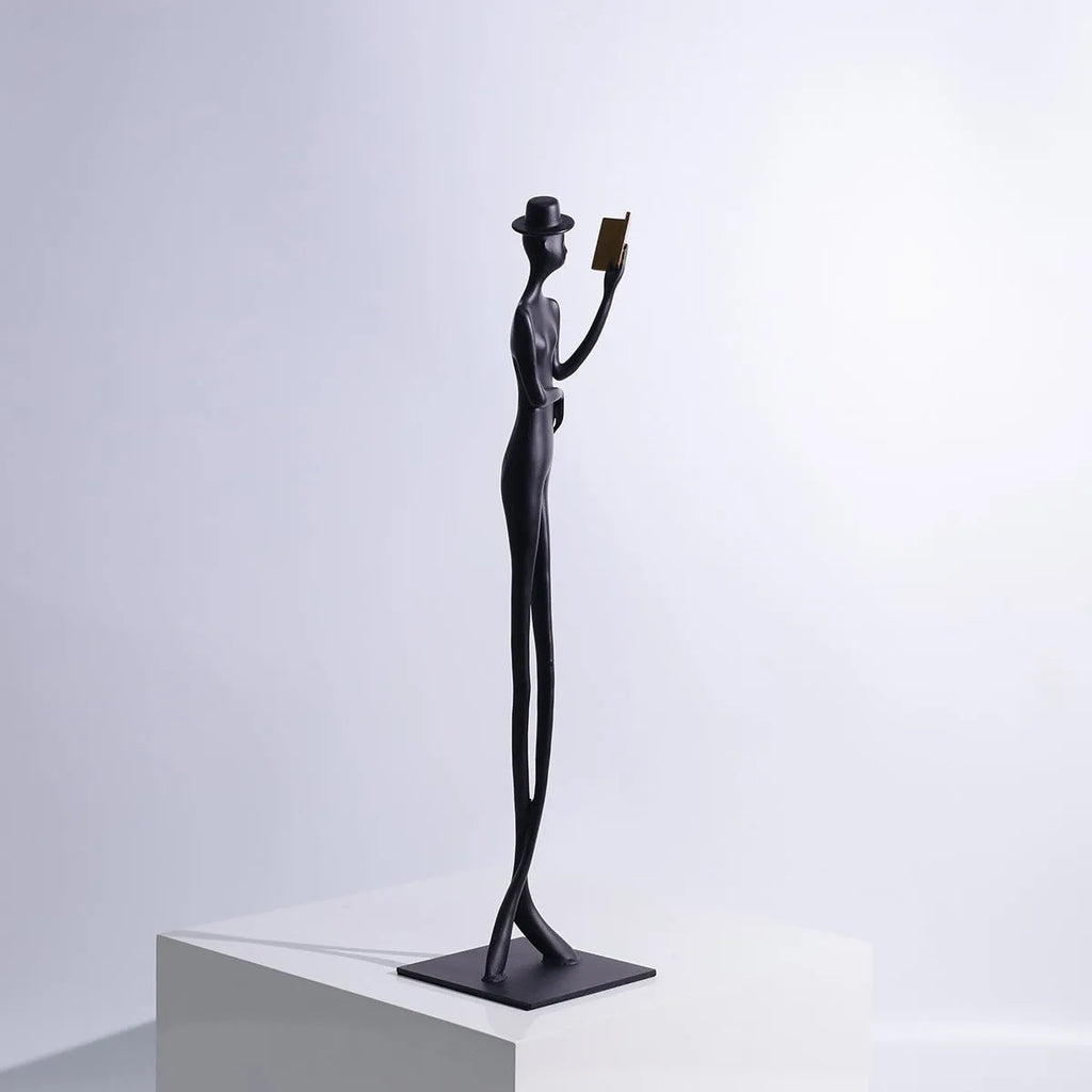 Black cast aluminium sculpture of a woman reading, modern design, 51cm tall.