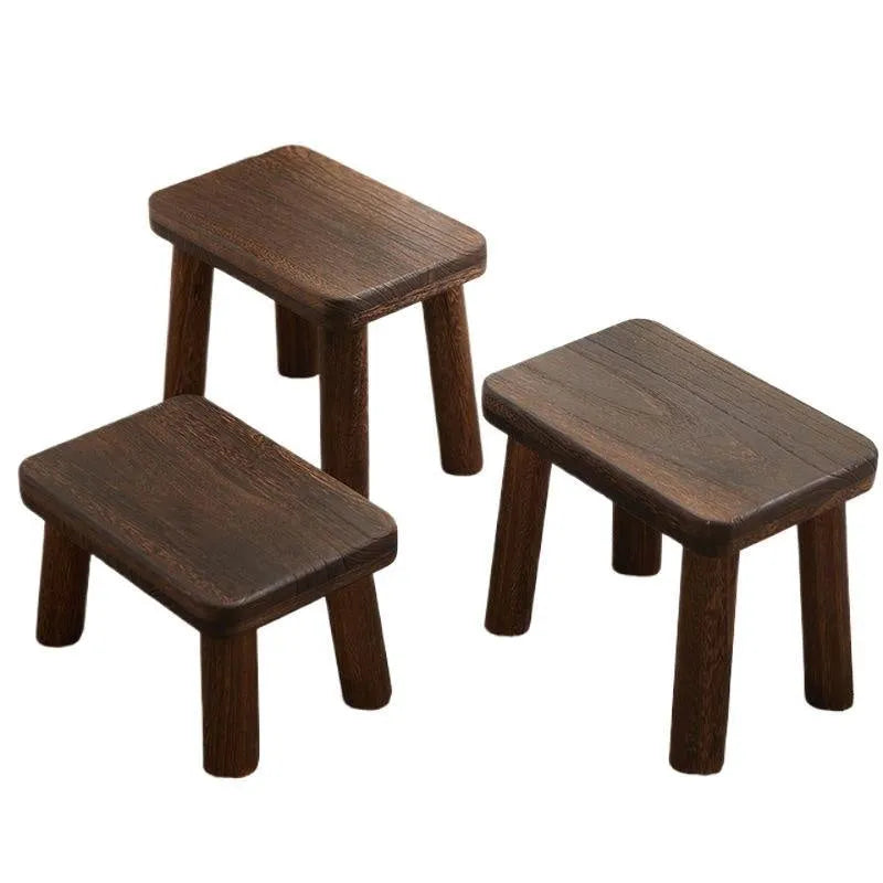 Solid wood household changing stool with a distressed finish for shoes in a living room.