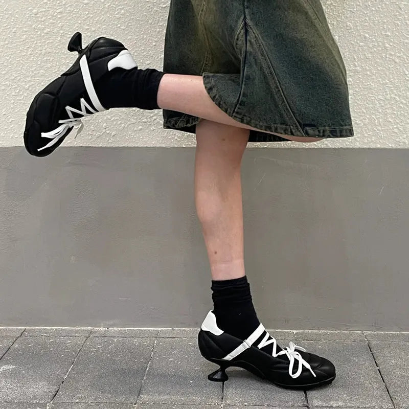 Women's silver lace-up sports shoes with a bow detail and a mid-height heel on a white background.