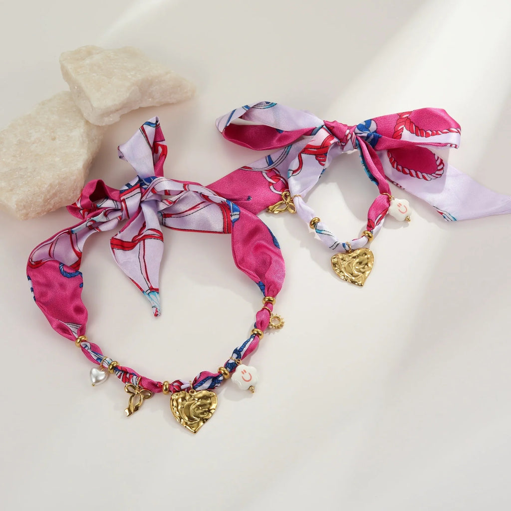 Women's geometric chain necklace and bracelet set with colourful pendant on a white background.