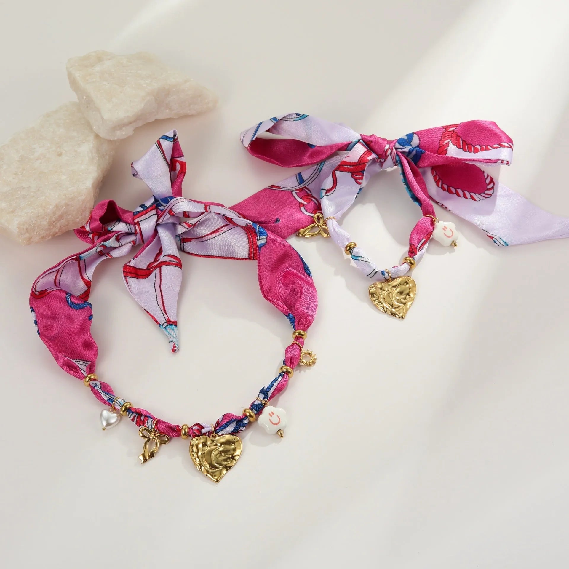 Women's geometric chain necklace and bracelet set with colourful pendant on a white background.
