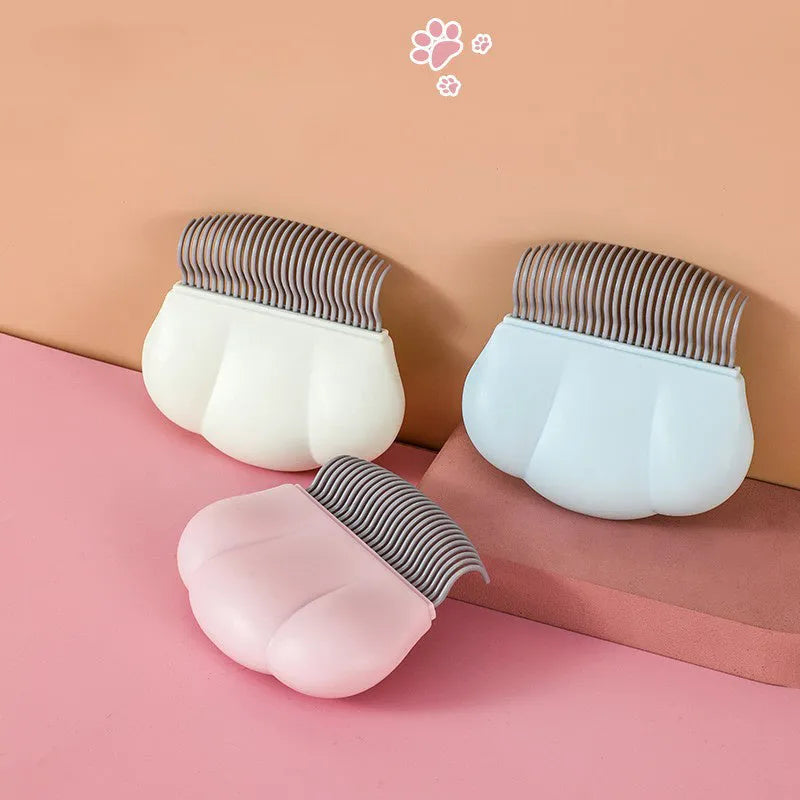 Blue paw-shaped deshedding brush for pets on a white background.