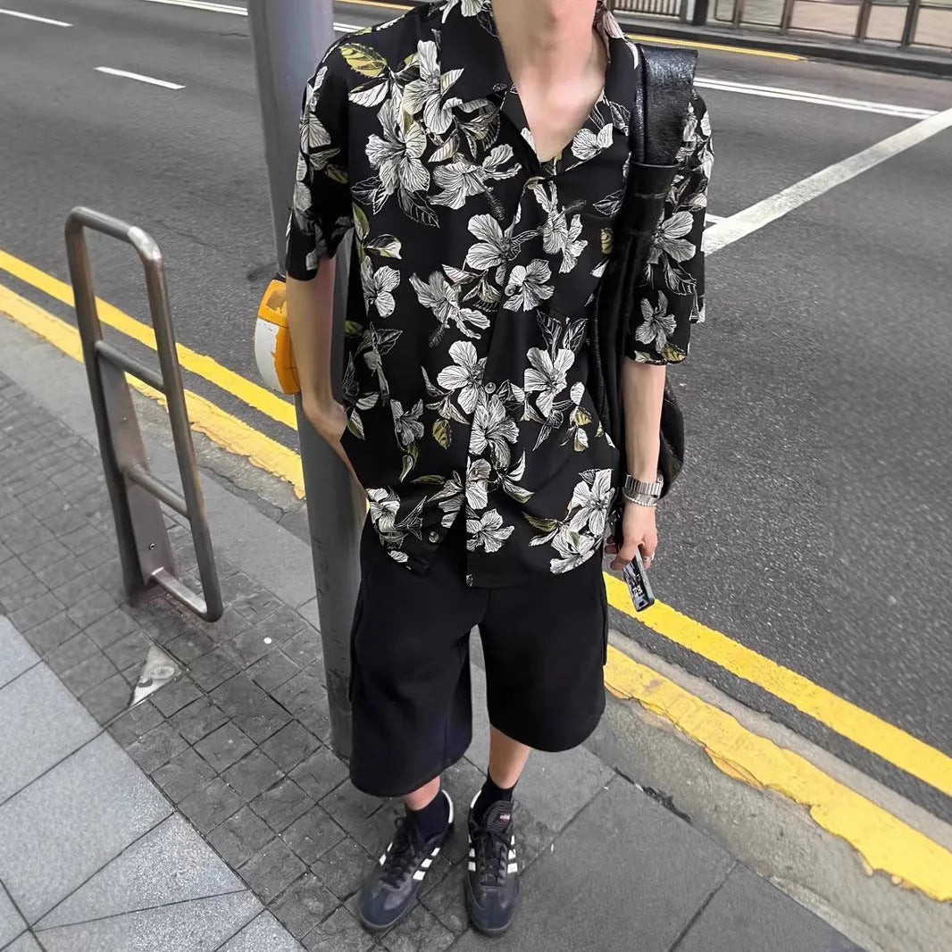 Man wearing a black ice silk shirt with floral print, Cuban collar, and short sleeves.