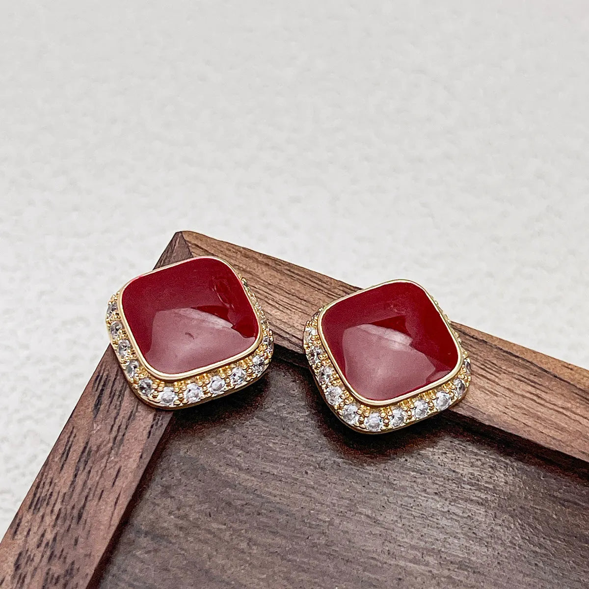 Red geometric square earrings with inlaid design details on alloy material