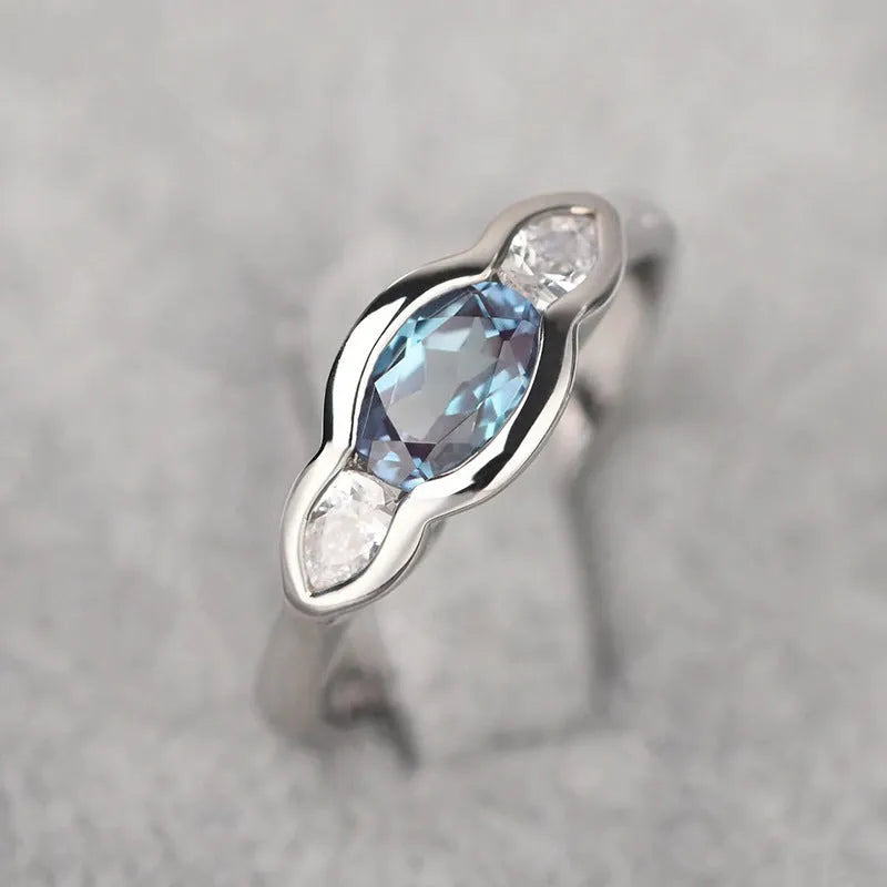 Geometric ellipse-shaped women's ring with inlaid zircon stones in a white gold finish.