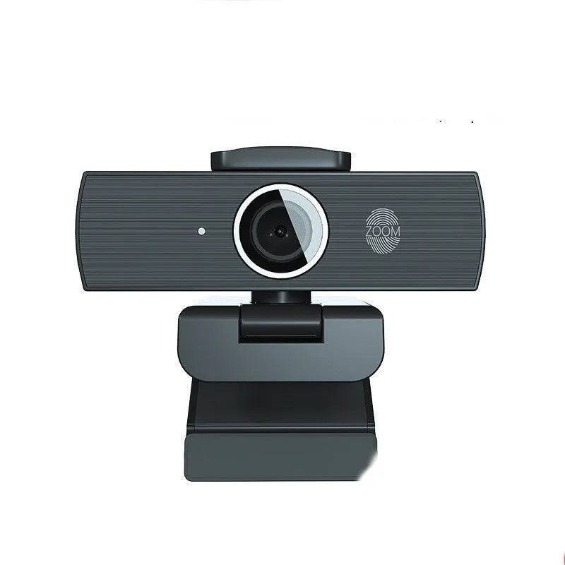 Matte black 4K USB webcam on a desk with a detached magnetic privacy cover and a long cable.