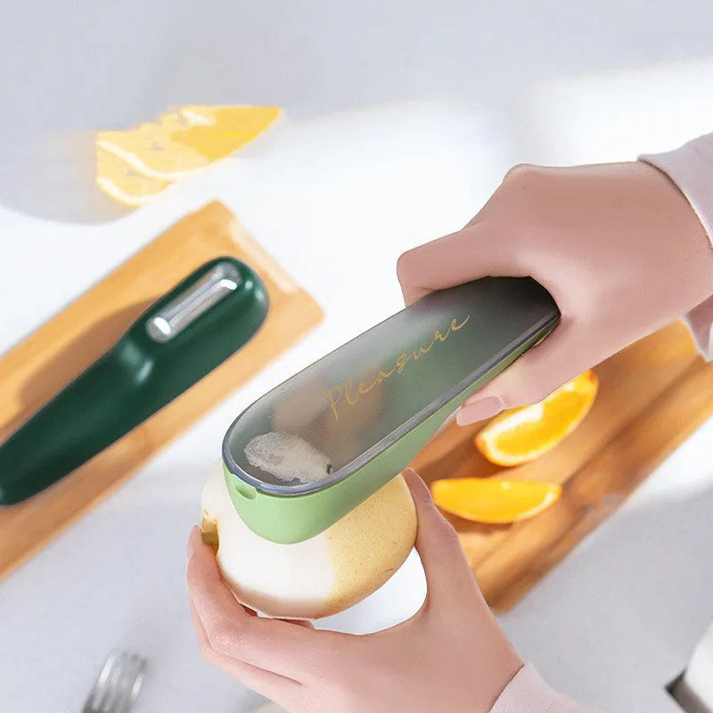 Dark green kitchen peeler with stainless steel blade inside its open storage tube on a counter.