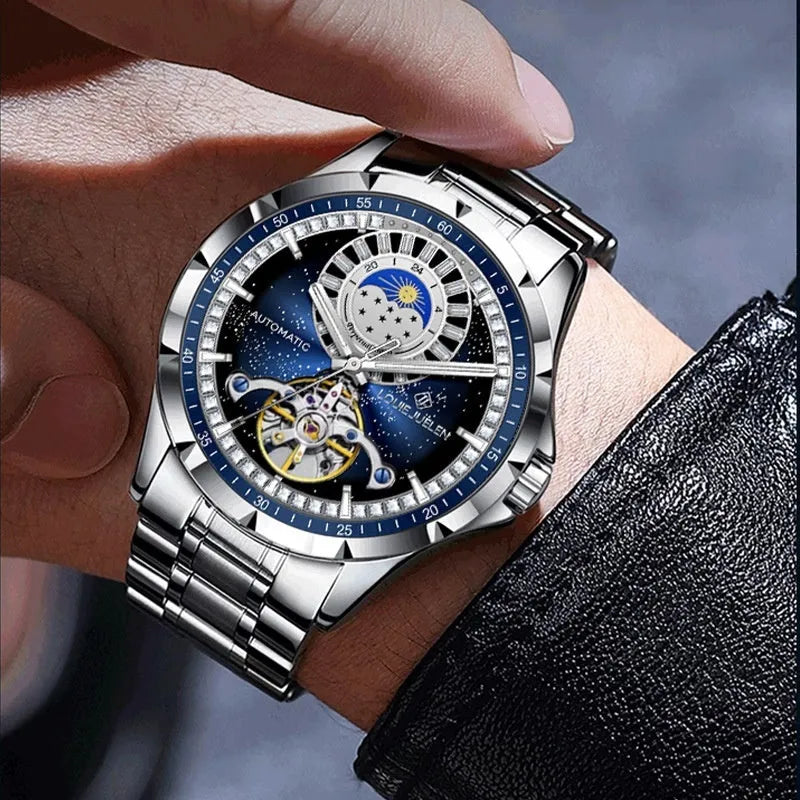 Men's silver automatic mechanical watch with blue dial, stainless steel strap, and transparent case back showing movement