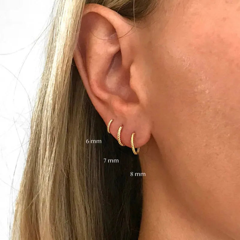 Twisted sterling silver round ring earrings in gold and white gold finishes showing multiple sizes