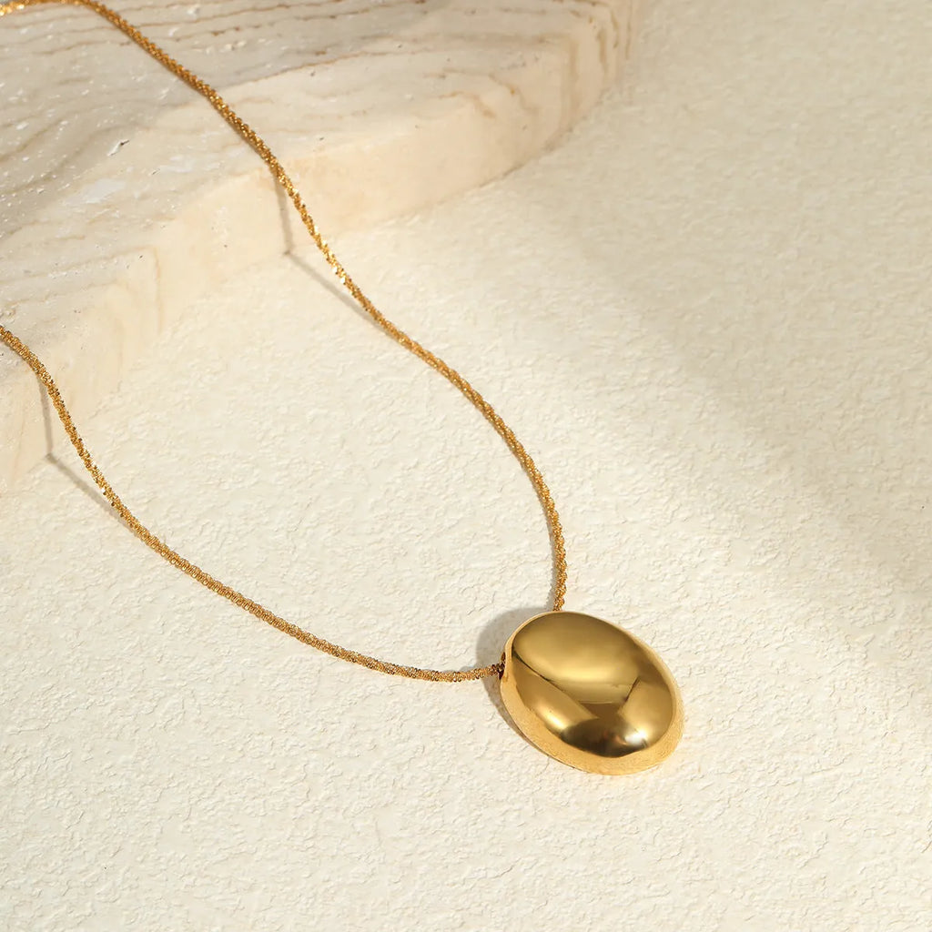 Gold geometric pendant necklace with adjustable chain on white background