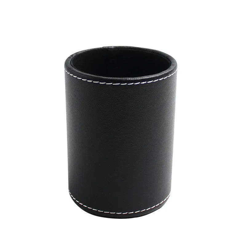 Black leather round pen holder with cylindrical shape on a desk