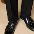 Black leather tassel loafers with polished finish and decorative tassel detail