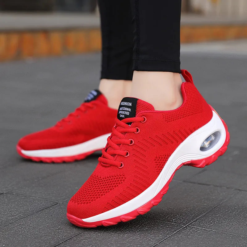 Women's red and black mesh front lace-up low top sneakers with round toe and flat mid-heel on a white background.