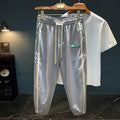 Man wearing grey cotton harem pants with a mid-waist and loose-fitting trousers-length legs.