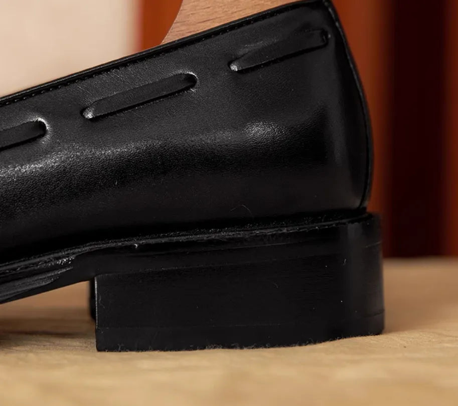 Men's black genuine leather slip-on loafers with fringed detailing on a white background