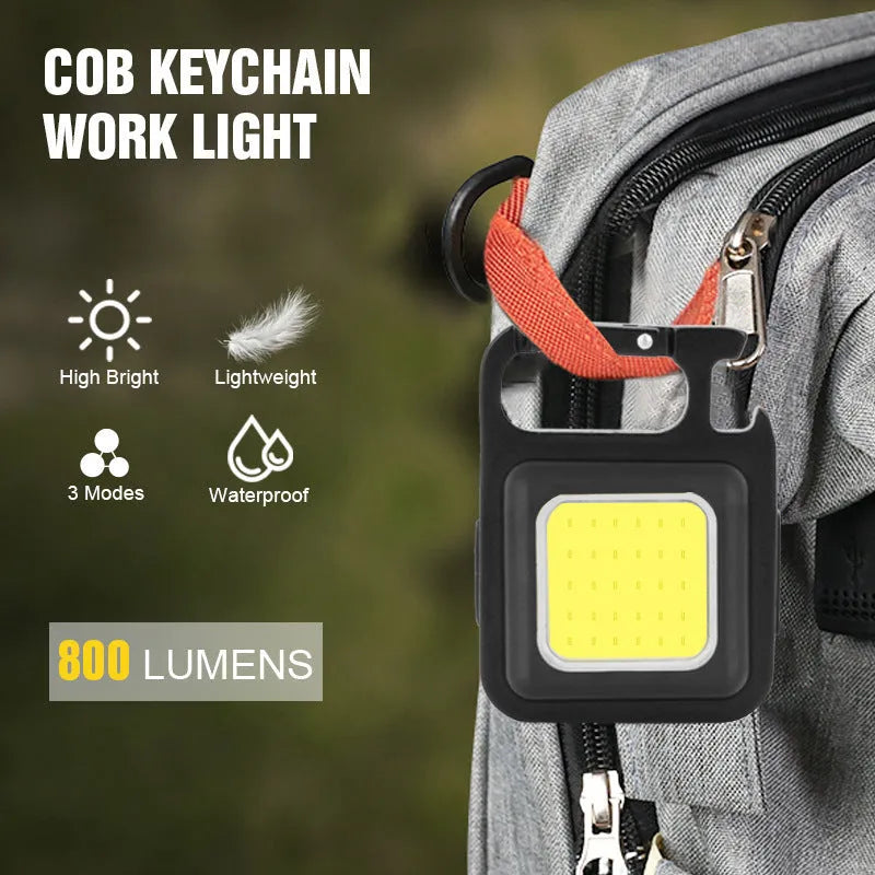 Black aluminium alloy USB rechargeable keychain light with LED, magnet, and folding handle