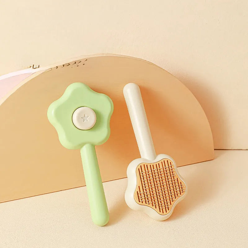 Green self-cleaning stainless steel pet comb with removable needle head on a white background.