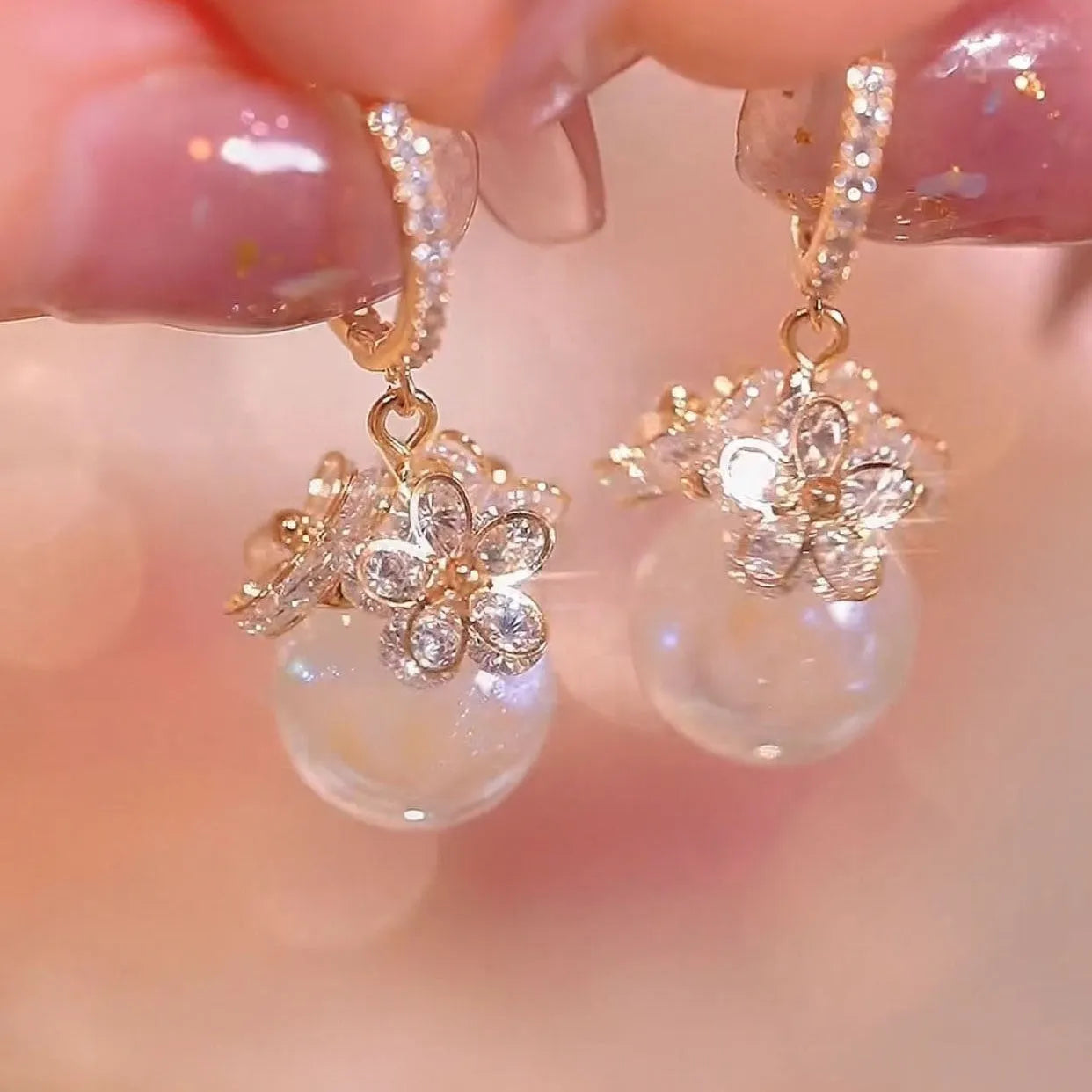 A pair of women's geometric rose design earrings in electroplated copper with zircon detail.