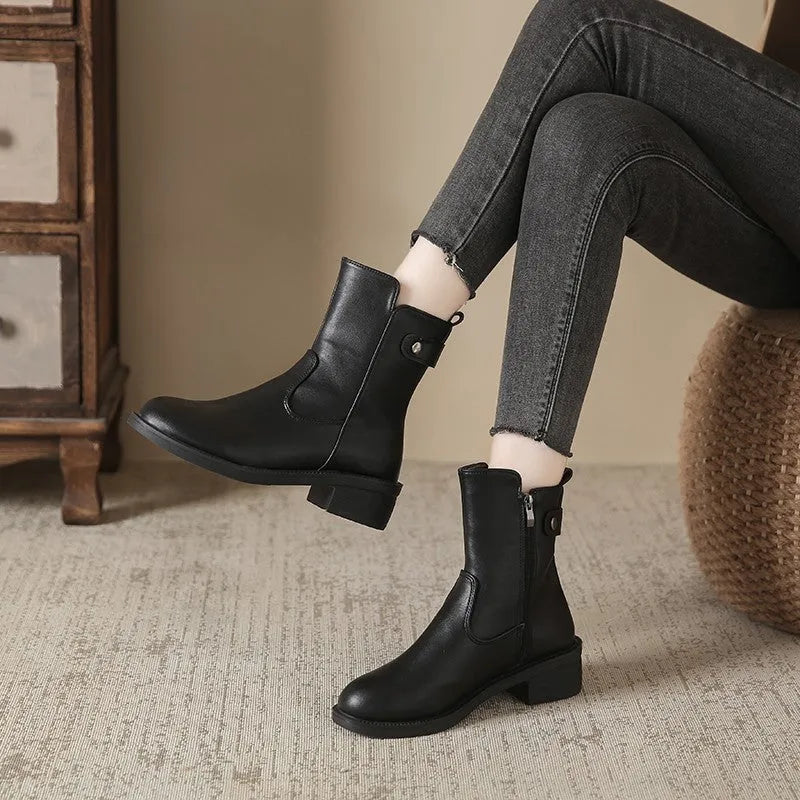 Black women's ankle boots with side zip and low round toe on a rubber sole.