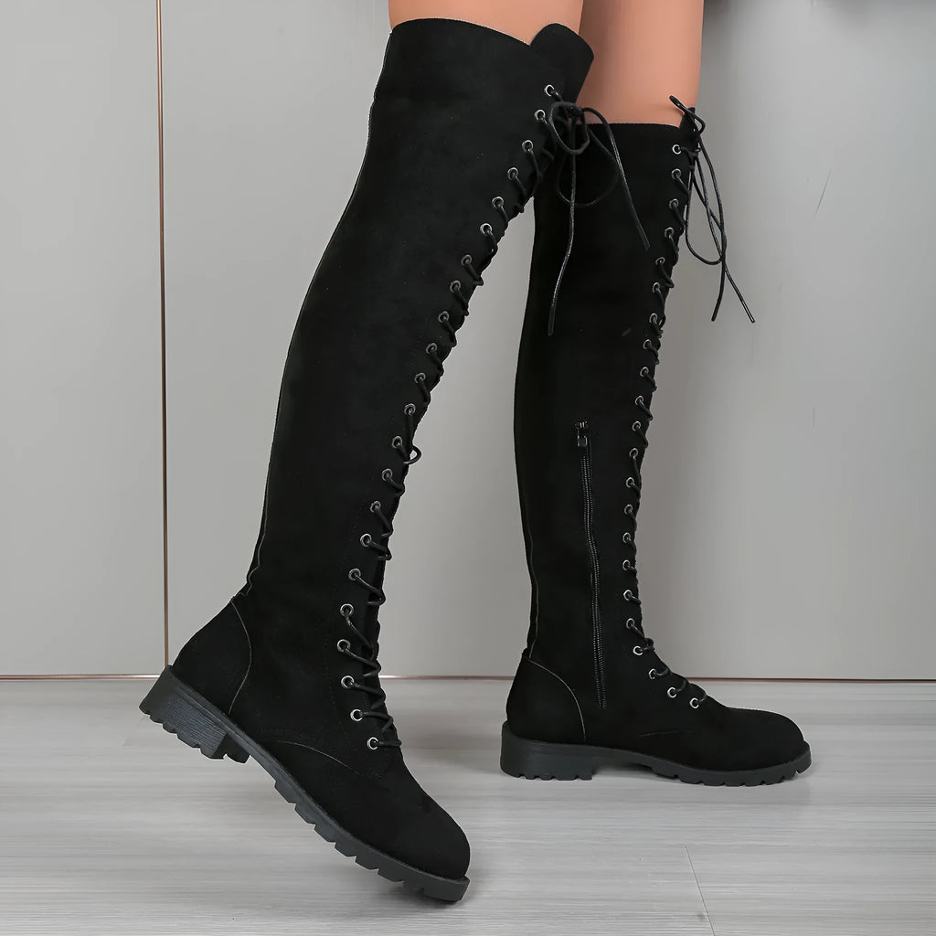 Black women's lace-up over the knee boots with round toe and flat rubber sole on a neutral background.