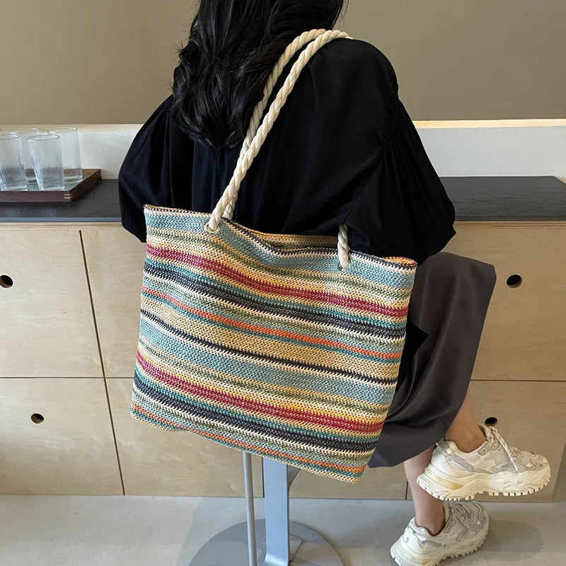 Blue woven straw-effect nylon shoulder bag with a single strap and large main compartment.