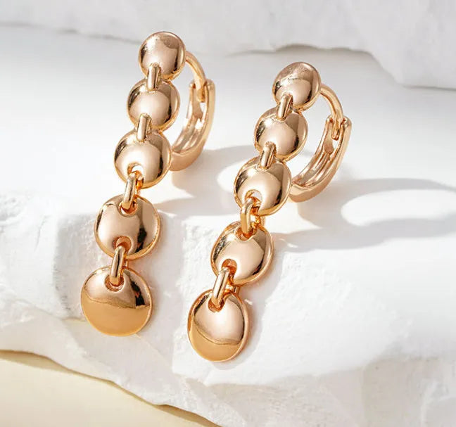 Gold tone retro earrings with a round circle shape and surface weave design, hanging as a dangle.