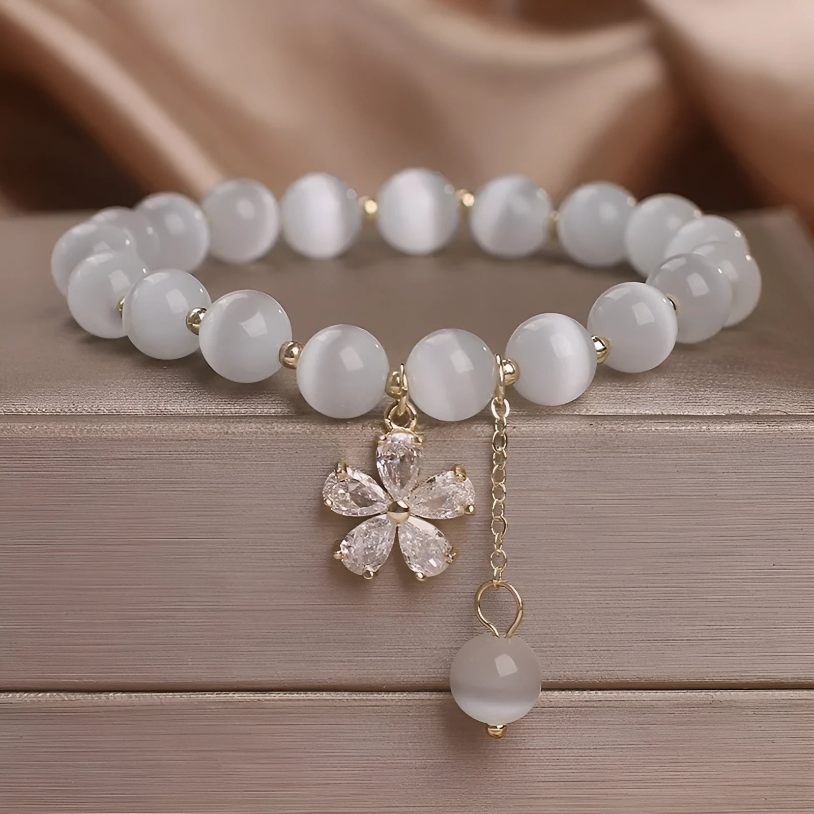 Women's white cat's eye stone bracelet with flower tassel pendant and safety buckle clasp