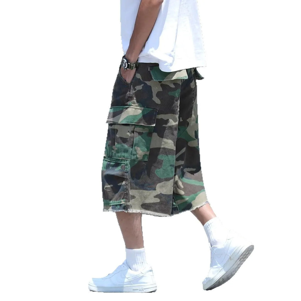 Man modelling loose-fit camouflage shorts in a retro workwear style for summer.