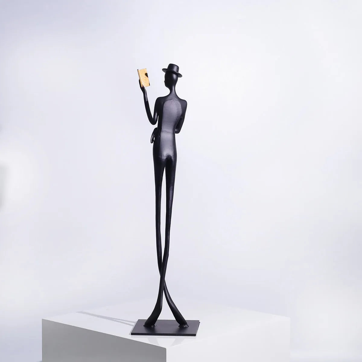 Black cast aluminium sculpture of a woman reading, modern design, 51cm tall.