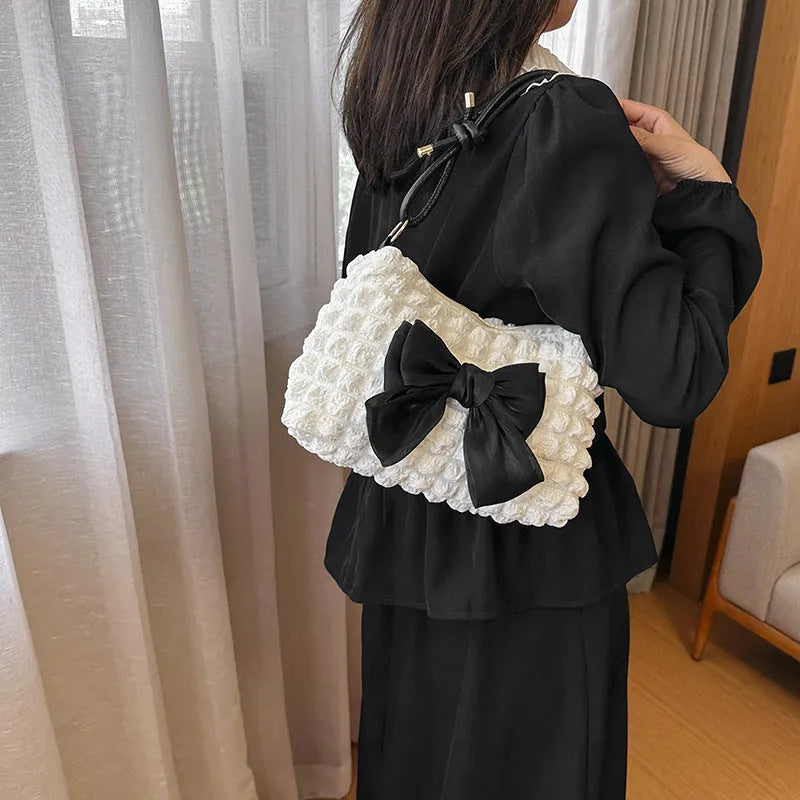 Women's black canvas handbag with single shoulder strap showing horizontal square shape and sandwich pocket