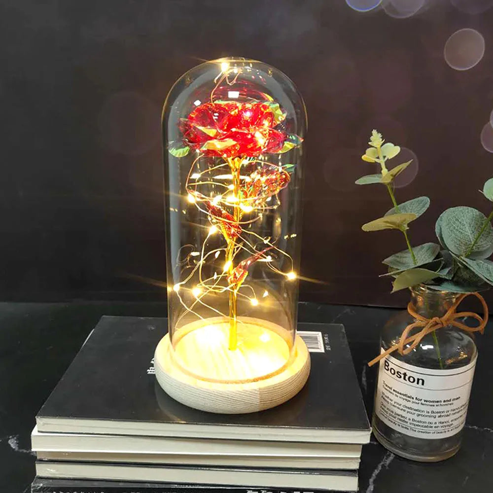 LED silk rose bouquet with glass lampshade glowing with warm white light on a solid wood base.