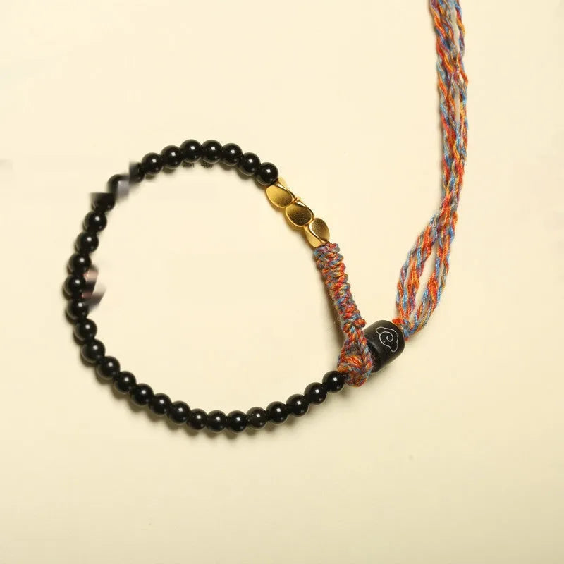 Hand-woven obsidian carrying strap bracelet showing textured surface and dark colour