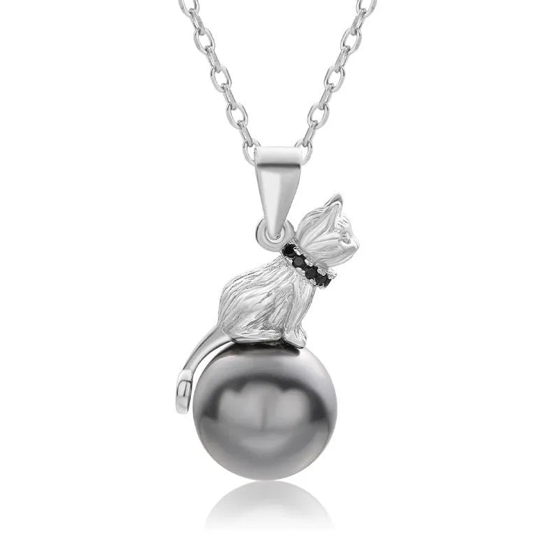 Close-up of a sterling silver cat pendant on a clavicle necklace chain.