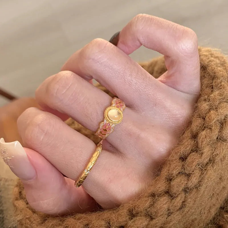 Geometric open mouth ring with pink crystal enamel on a gold-plated copper band.