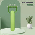 Green dog grooming comb with stainless steel teeth and a curved plastic handle for detangling matted fur.