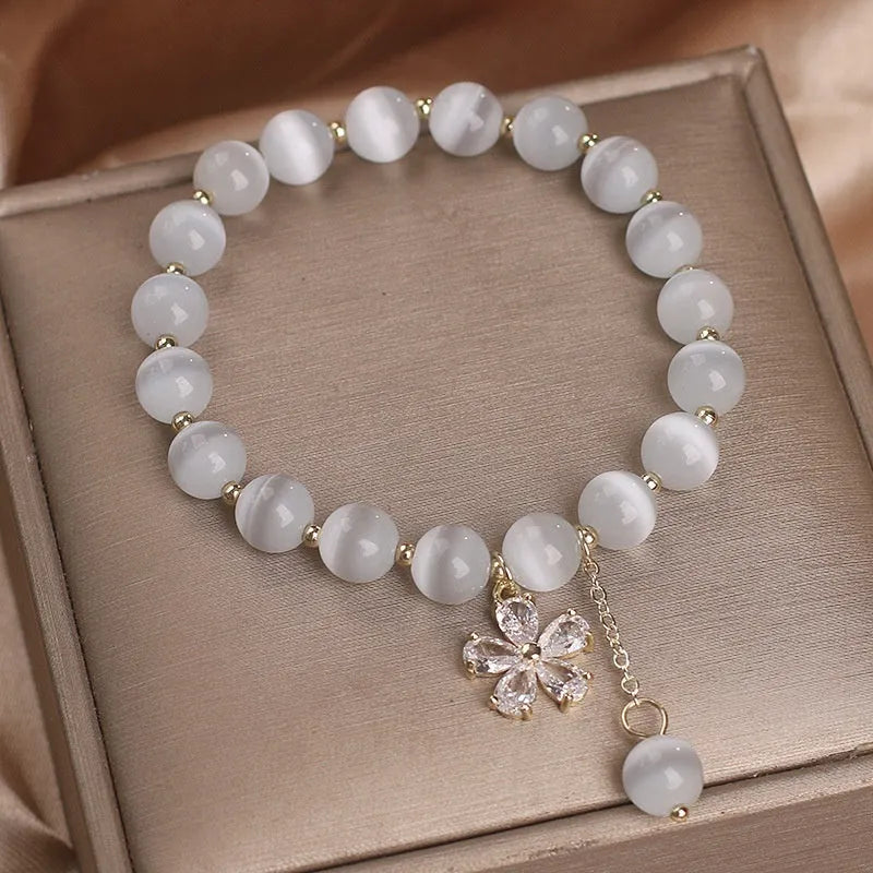 Women's white cat's eye stone bracelet with flower tassel pendant and safety buckle clasp