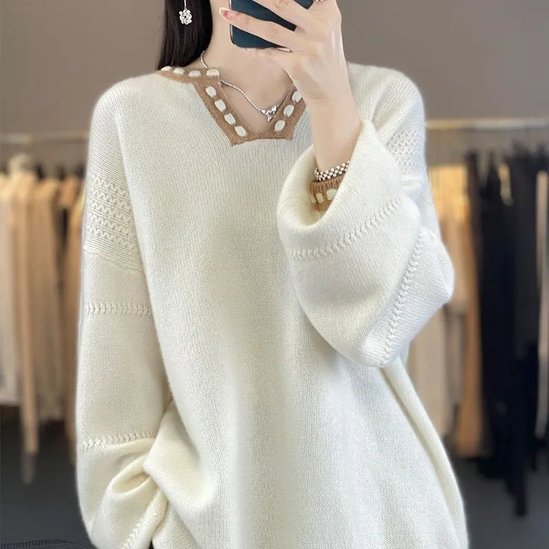 White women's V-neck long sleeve pullover sweater made from viscose knit fabric on a hanger.