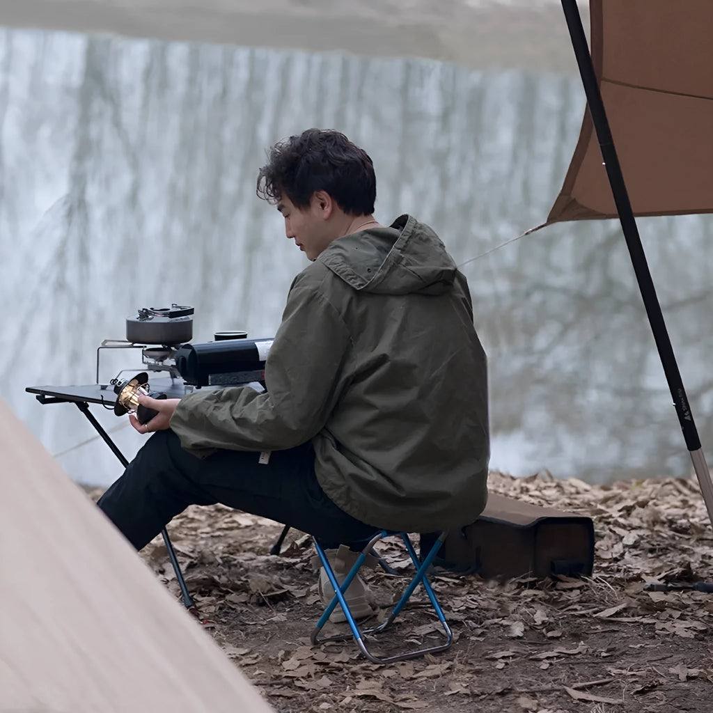 Black ethnic style aluminium alloy folding camp stool shown folded and unfolded.