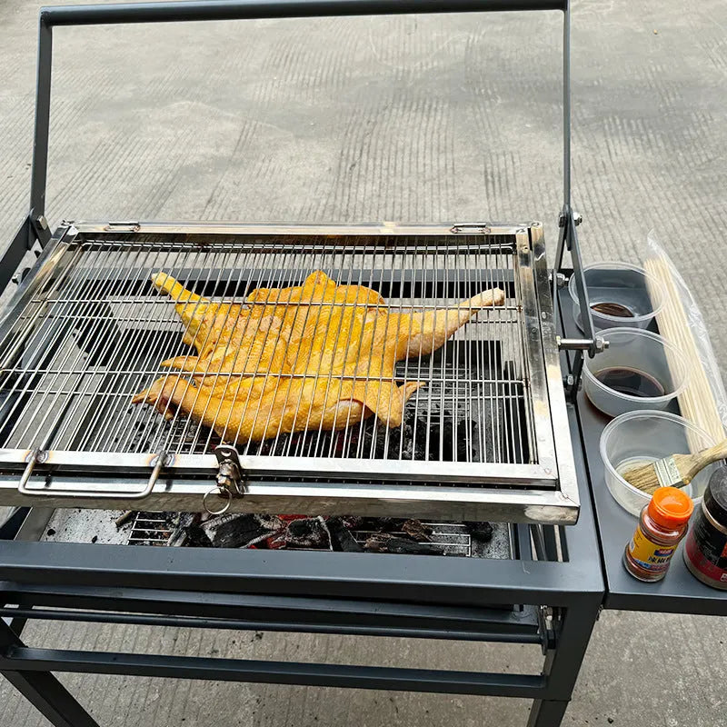 Large foldable and detachable charcoal BBQ grill oven set up in an outdoor courtyard setting.
