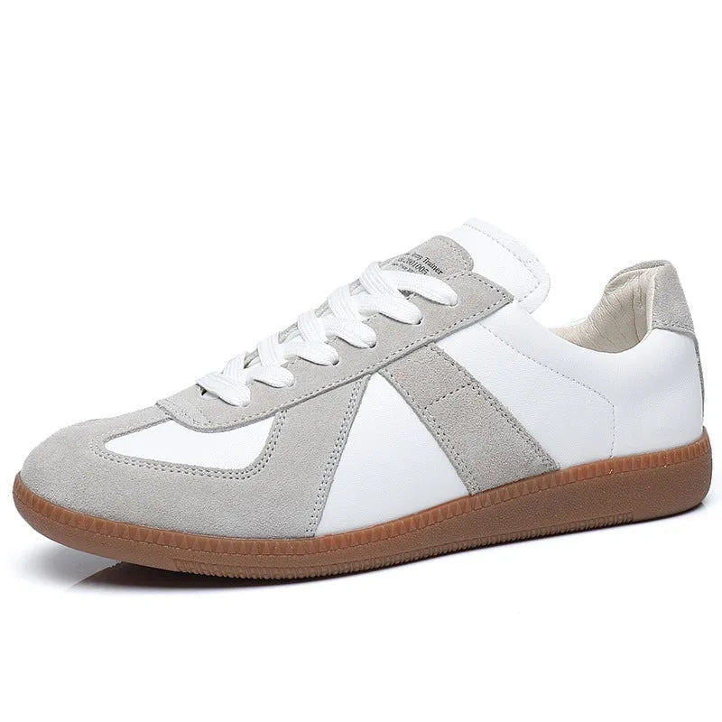 White Japanese retro low-top sneakers with round toe and lace-up front on a rubber sole.