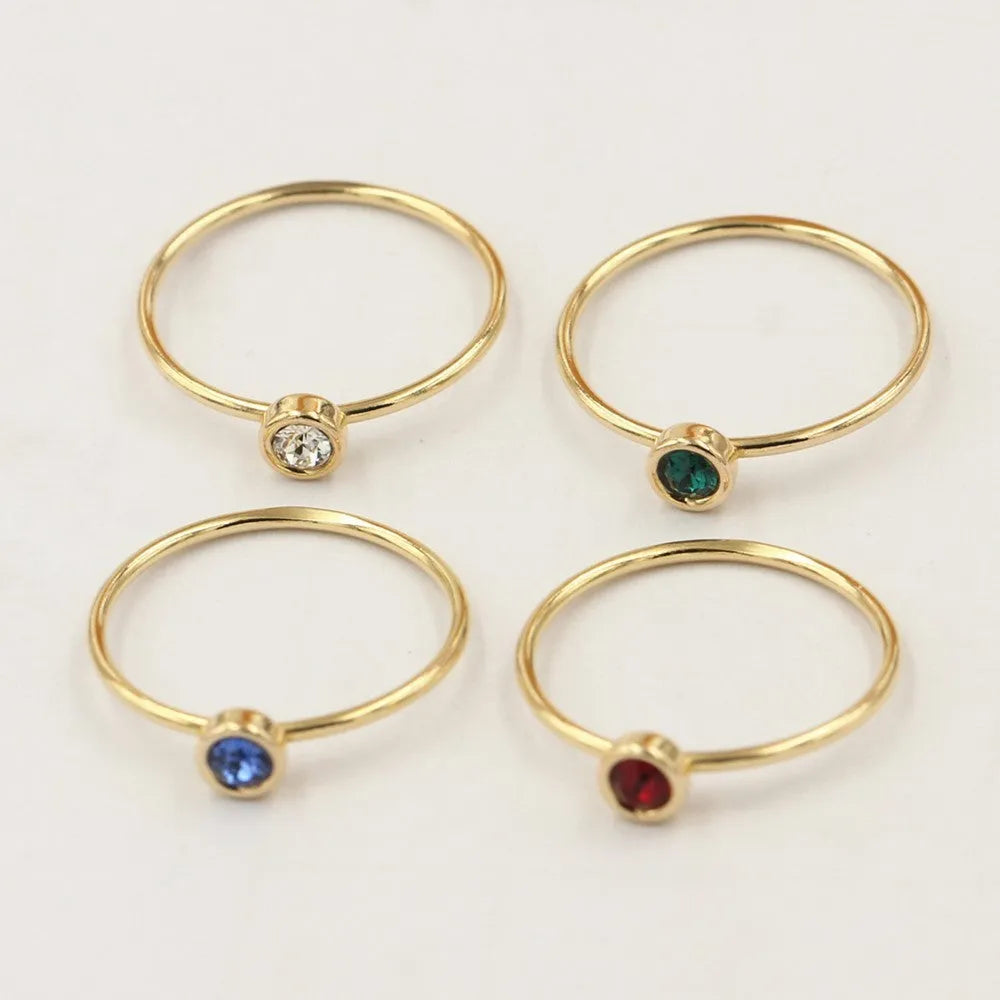 14K gilded gold filled zircon ring on a finger, showing green colour and zircon stones.
