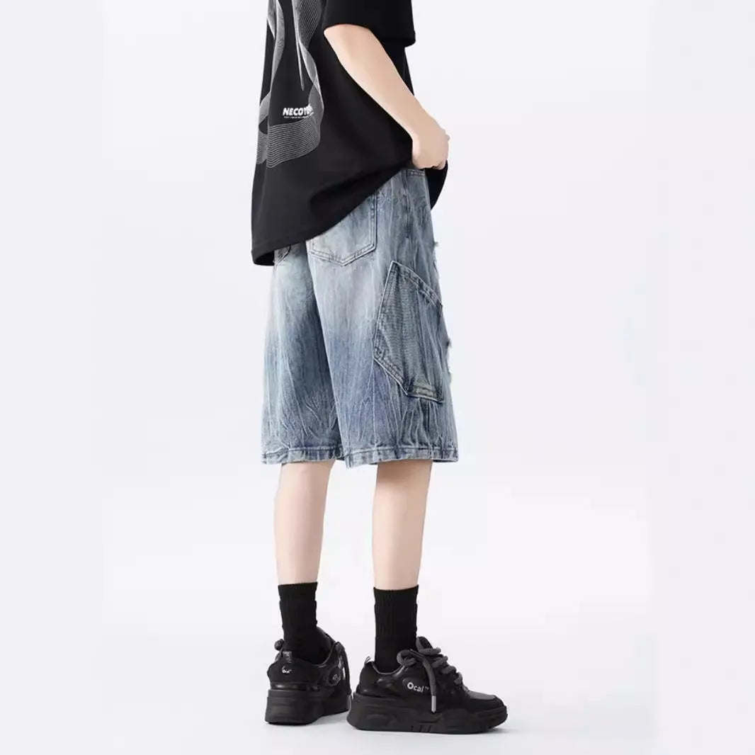 Model wearing loose-fit washed denim shorts with ripped details in blue.