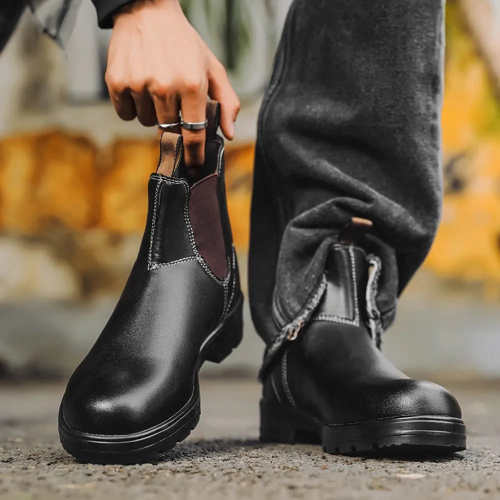 Vintage brown frosted finish Chelsea boots with car suture detailing on a wooden floor.