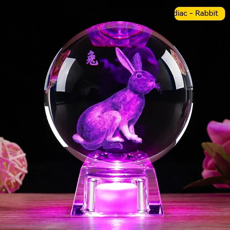 White luminous crystal ball ornament with Chinese zodiac animal figure on electronic base.
