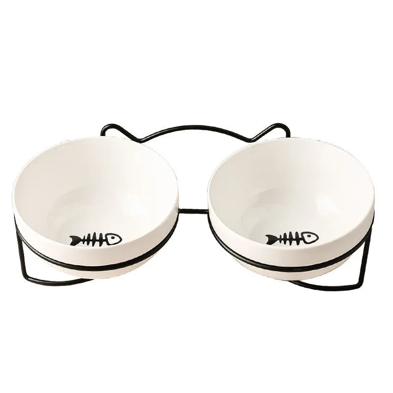 White ceramic cat food bowl with cat paw print design on black iron frame stand