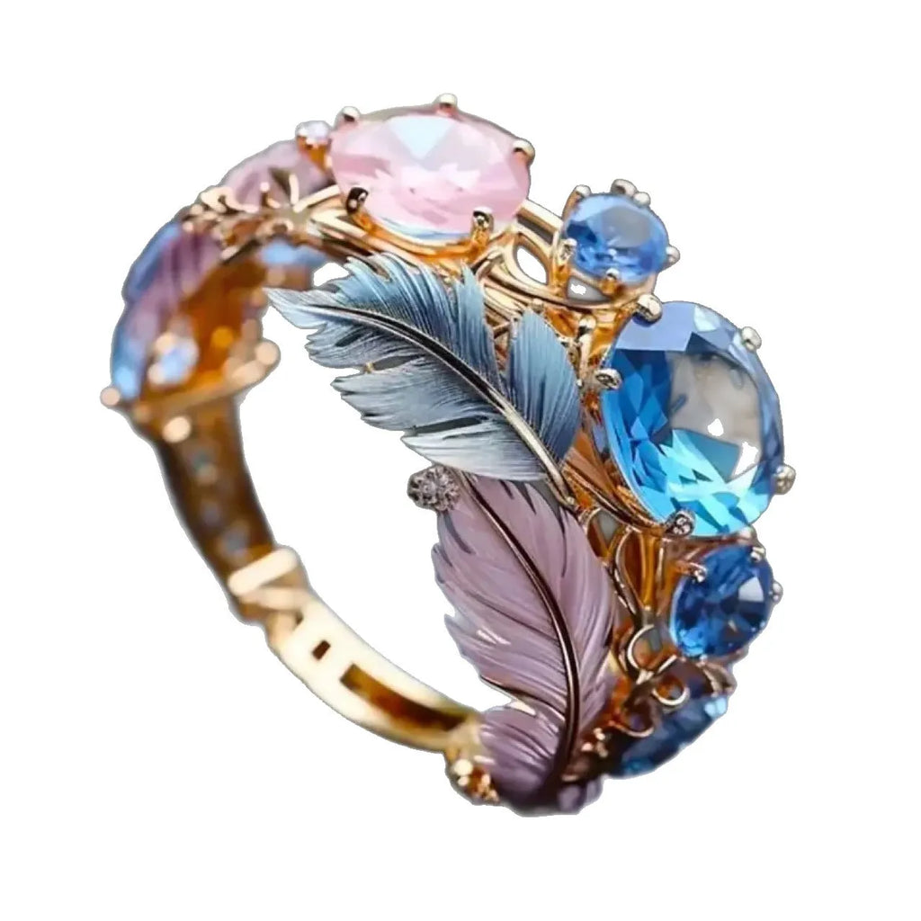 Gold coloured brass ring with an embossed geometric feather design and small zircon inlays.